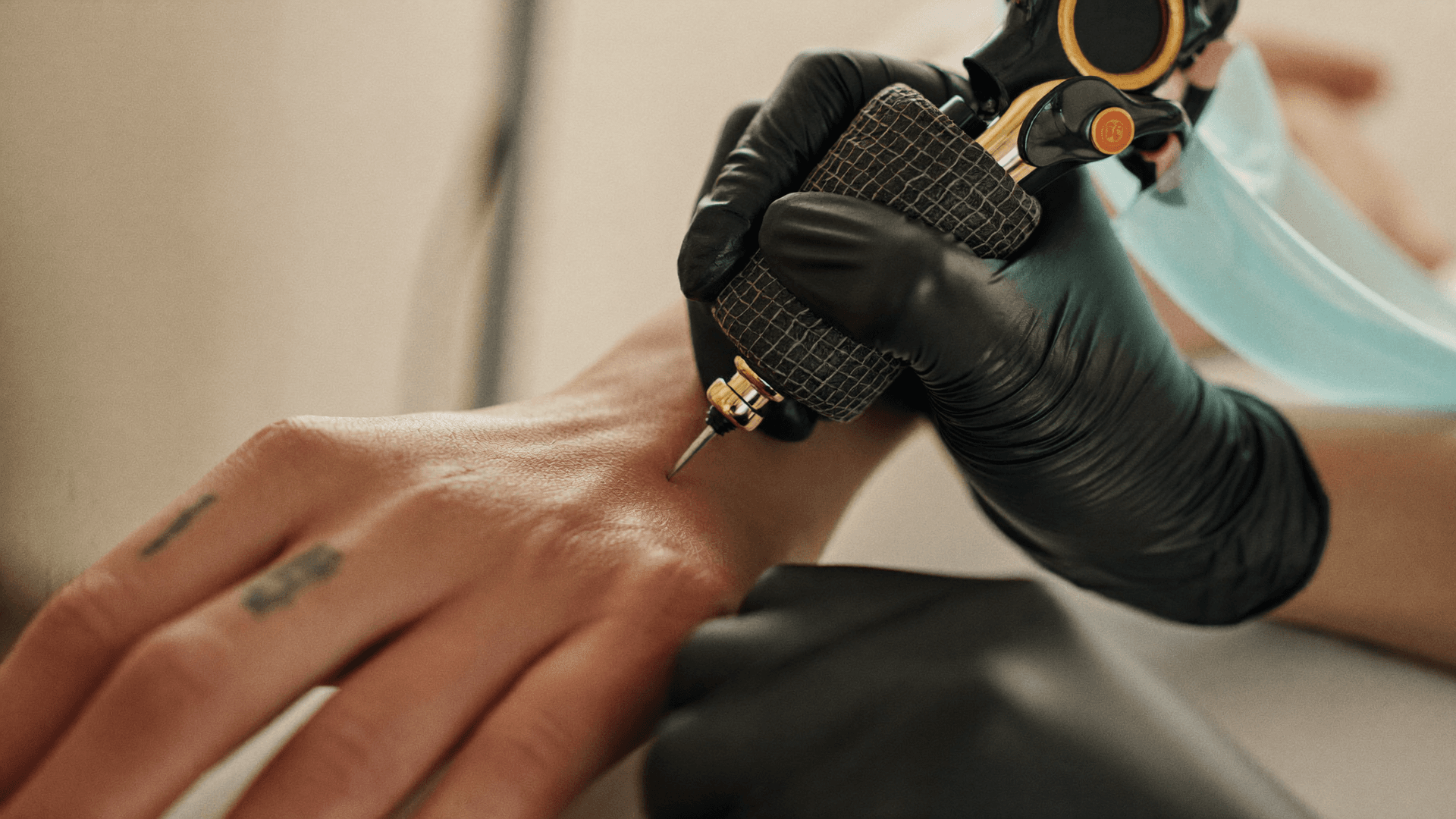 Gloved hands of a paramedical tattoo artist working carefully on skin